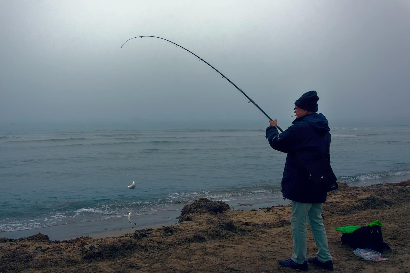 7 Best Beaches in the North East for Fishing: Top Coastal Spots for Anglers in 2026 Man fishing on foggy beach in Alicante, Spain at dawn.