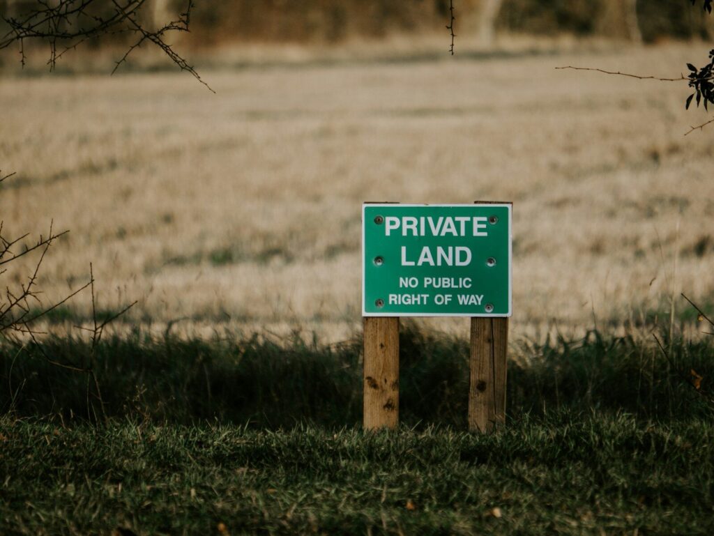 He Bought Land to Hunt—Then the HOA Next Door Tried to Stop Him From Hunting On His Own Land blue and white wooden signage on green grass field during daytime